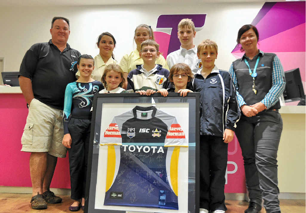 Warwick Gymnastics Club president Coby Walker with the club’s students and Bianca Jenkin from Telstra with the raffle prize – a signed North Queensland Cowboys jersey, donated by the Telstra Shop in Rose City Shoppingworld.